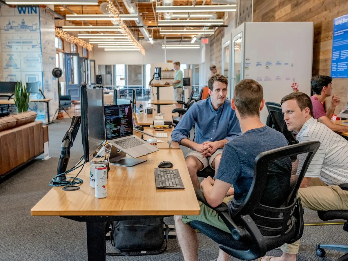 Jeunes entrepreneurs collaborant sur ordinateurs portables dans un espace de travail, illustration de l'écosystème startup visé par le Startup Act djiboutien